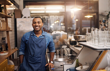 Canvas Print - Coffee shop, restaurant and happy portrait of man for service, working and welcome in cafe. Small business owner, bistro startup and male worker, waiter of barista smile by counter ready to serve