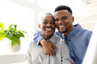 © Wavebreak Media - Happy african american young man with hand on boyfriend's shoulder sitting on sofa at home