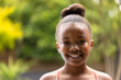 © Wavebreak Media - Portrait of smiling african american girl in garden, with copy space