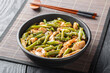 © FomaA - Asian style fried chicken fillet with asparagus in soy sauce close-up in a bowl on the table. Horizontal