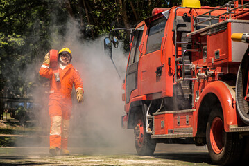 Wall Mural - With focused determination the firefighter marched forward, the weight of the fire hose resting securely on his shoulder a symbol of the responsibility he carried to combat the looming danger.