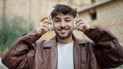 Canvas Print - Young arab man smiling confident listening to music at street