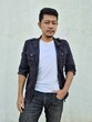 © Igunt - Cool modern young hipster man with a stylish hairstyle in a white T-shirt puts on a vintage black denim jacket. Attractive urban guy posing near a white wall. Fashionable spring menswear.