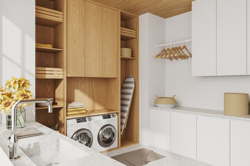 Stylish light interior of laundry room with washing machine and iron board