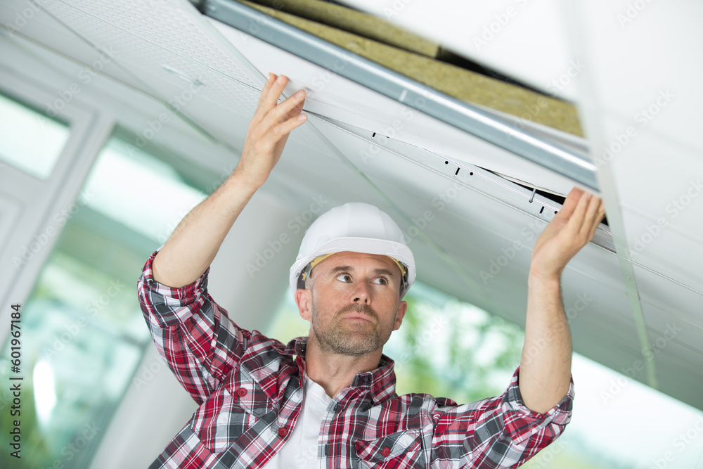 man in builder uniform hand up installing suspended ceiling Stock Photo ...