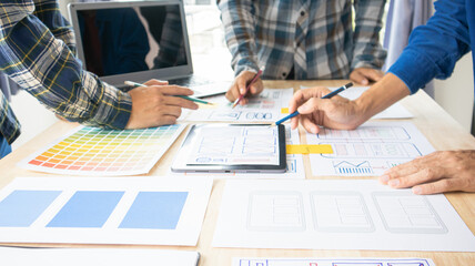 Close-up ux developers and ui designers use augmented reality to brainstorm on mobile app interface wireframe designs on modern office desks. Creative digital development office
