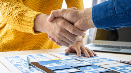 Close-up ux developers and ui designers use augmented reality to brainstorm on mobile app interface wireframe designs on modern office desks. Creative digital development office