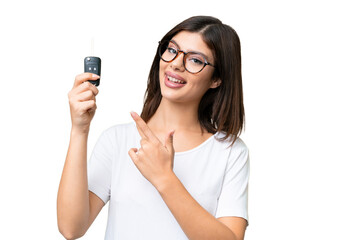 Canvas Print - Young Russian woman holding car keys over isolated chroma key background and pointing it