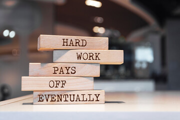 Wall Mural - Wooden blocks with words 'Hard work pays off eventually'.