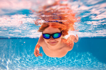 Kid swimming in pool underwater. Child boy swim underwater in sea. Child playing and diving in swimming pool. Funny kids boy play and swim in sea or pool water. Summer vacation concept.