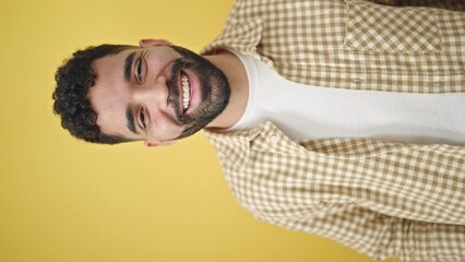 Poster - Young hispanic man smiling confident speaking over isolated yellow background