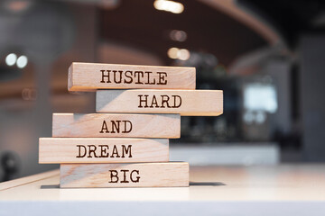 Wooden blocks with words 'Hustle hard, dream big'.