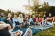 © Alessandro Biascioli - Happy multi generational people having fun sitting on grass in a public park - Diversity and friendship concept