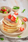Fototapeta Kawa jest smaczna - Delicious and hot american pancakes with strawberries and sugar.