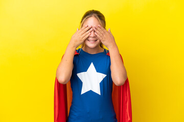 Wall Mural - Super Hero little girl isolated on yellow background covering eyes by hands