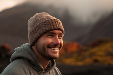 Sticker - Medium shot portrait photography of a grinning man in his 30s wearing a warm beanie or knit hat against a volcano or lava background. Generative AI