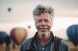 © Robert MEYNER - Medium shot portrait photography of a pleased man in his 50s wearing a denim jacket against a hot air balloon or skydiving background. Generative AI