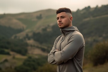 Wall Mural - Medium shot portrait photography of a satisfied man in his 20s wearing a comfortable tracksuit against a hillside or rolling hills background. Generative AI