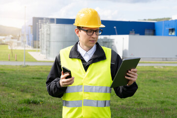 Aufkleber - Engineer with phone and digital tablet on a background of modern factory