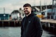 Medium shot portrait photography of a pleased man in his 30s wearing a comfortable tracksuit against a fishing village or dock background. Generative AI
