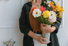 Close-up Of A Woman Holding A Vase Of Flowers