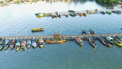 Wall Mural - Aerial drone shot over the traditional wharf with moored boats in Gresik, Indonesia. Aerial footage.