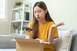 © KMPZZZ - Complaint asian young woman hand using mobile phone take a photo product order from retail store after open carton box, received online shopping parcel wrong with support shop want to return package.