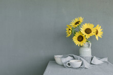 Bunch Of Sunflowers In A Vase On A Table With Ceramic Crockery And A Napkin