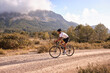 Cyclist practicing on gravel road.Fit male cyclist riding a gravel bike on a gravel road with a view of the mountains, Alicante region of Spain