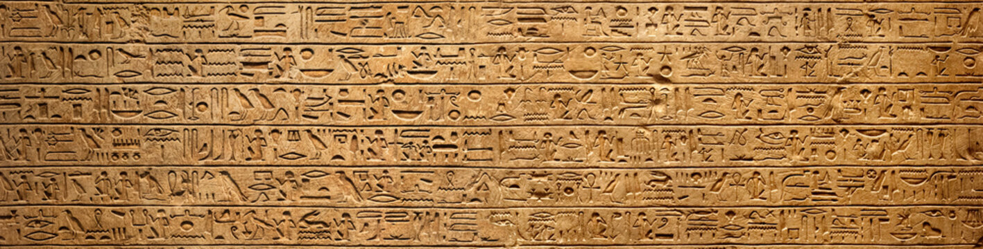 Old Egyptian hieroglyphs on an ancient background. Wide historical background. Ancient Egyptian hieroglyphs as a symbol of the history of the Earth.