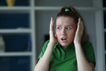 Young european woman sitting on the sofa at home afraid and shocked with surprise expression, fear and excited face.