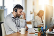 © Donson/peopleimages.com - Headache, stress or tired man in call center with burnout, head pain or overworked in crm communication. Migraine, office or telemarketing sales agent frustrated with anxiety, fatigue or problems