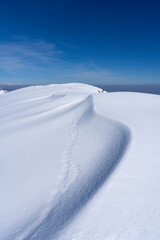 snowdrifts on top of the alpine mountain. snow dune lines, texture and shapes background