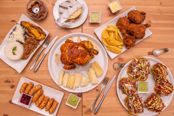 Wall Mural - Latino cuisine dishes set with roasted chicken, broster chicken, patacones with sauces