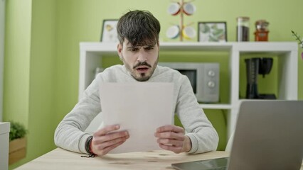 Poster - Young hispanic man stressed reading document at dinning room