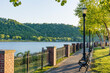 Walkway along the Ohio River in Madison, Indiana with a wrought iron fence and lamp posts in the evening.