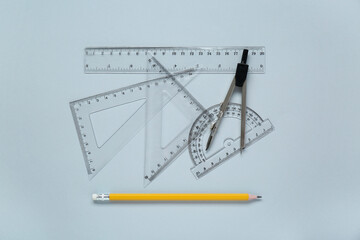 Wall Mural - Different rulers with measuring length markings and compass on light grey background, flat lay