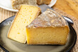 © barmalini - Pieces of cheese tomme de montagne or tomme de savoie made from cow milk in French Alps close up
