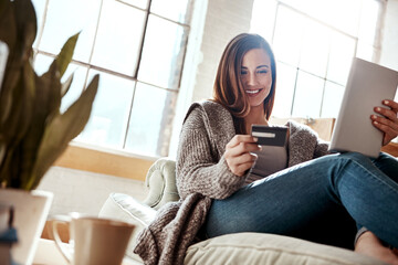Smile, tablet and credit card, happy woman on couch in living room and internet banking or fintech in home. Technology, online shopping payment and girl on sofa surfing retail website or digital shop