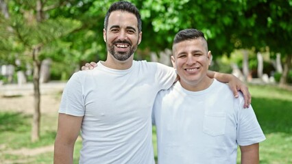 Wall Mural - Two men smiling confident hugging each other at park