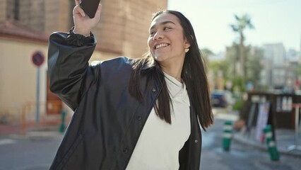 Canvas Print - Young beautiful hispanic woman smiling confident using smartphone dancing at street