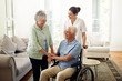 © Anne/peopleimages.com - Smile, old man in wheelchair with wife and nurse at nursing home for disability help and rehabilitation. Healthcare, disability and happy senior couple with caregiver in living room for elderly care.