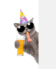 Aufkleber - Happy cat wearing sunglasses and party cap looks from behind empty white banner and holds glass of beer. isolated on white background