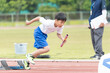 陸上大会でリレーを走る小学生の男の子