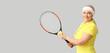 Mature female tennis player on grey background with space for text