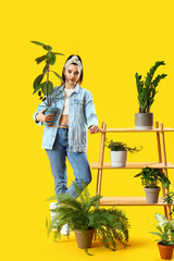 Canvas Print - Young woman and shelving unit with green houseplants on yellow background