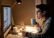 © Marius Venter/peopleimages.com - Young, man and student studying at night on a desk computer in a bedroom. College, male and elearning at apartment with coffee to study with technology and the internet for education at university.