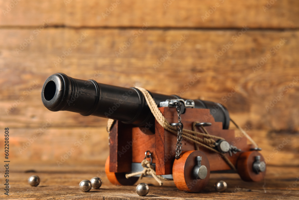 Toy model of cannon on wooden background