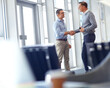© GR/peopleimages.com - Business people, handshake and greeting in modern office, company lobby or airport lounge for teamwork collaboration. Men, shaking hands and partnership gesture for corporate workers in welcome deal
