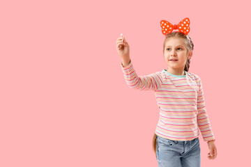 Wall Mural - Little girl with chalk piece on pink background. Children's Day celebration